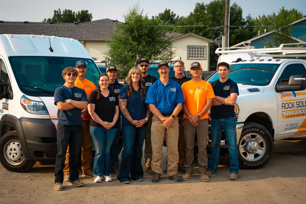The Rock Solid Plumbing Heating and Air crew with their service vehicles